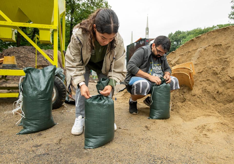 Volunteers Arielle Castro, left, and Bruno Dacruz fill sandbags at the Leominster Emergency Management headquarters Wednesday.