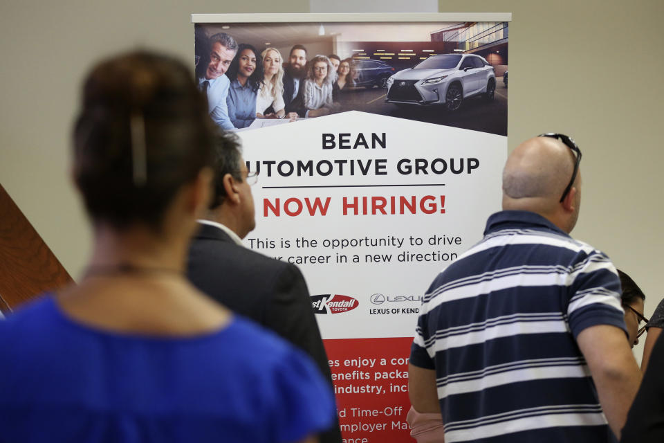 FILE - In this Sept. 18, 2019, file photo people stand in line to inquire about jobs available at the Bean Automotive Group during a job fair designed for people fifty years or older in Miami. On Wednesday, Dec. 4, payroll processor ADP reports on how many jobs its survey estimates U.S. companies added in November. (AP Photo/Lynne Sladky, File)