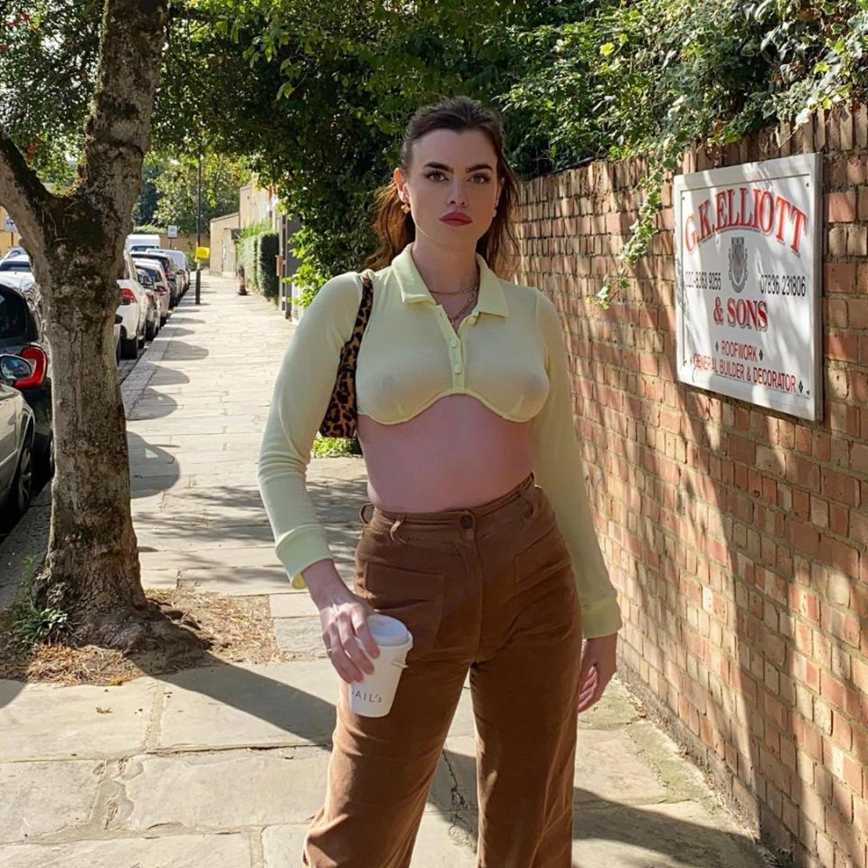 Model Charli Howard wearing a yellow bra-top and brown corduroy pants