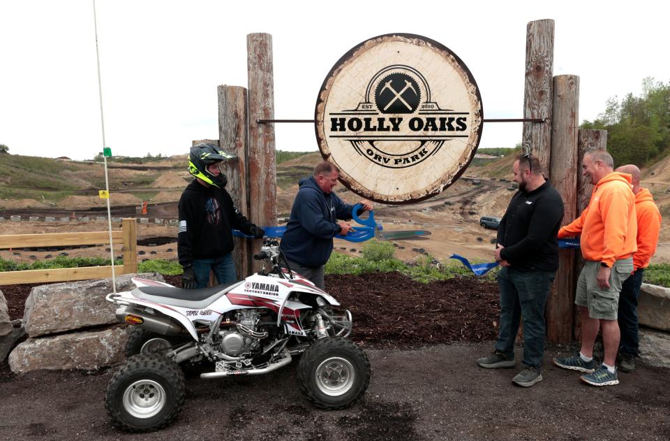 (Center) Jamie Weasel,  49 of Grand Blanc and the Holly Oaks park supervisor officially opens the newly created youth course at Holly Oaks ORV Park in Holly on Saturday, May 20, 2023.  
The off road park held an event where kids on various recreational vehicles could ride for free to help promote the new section of the off road course.