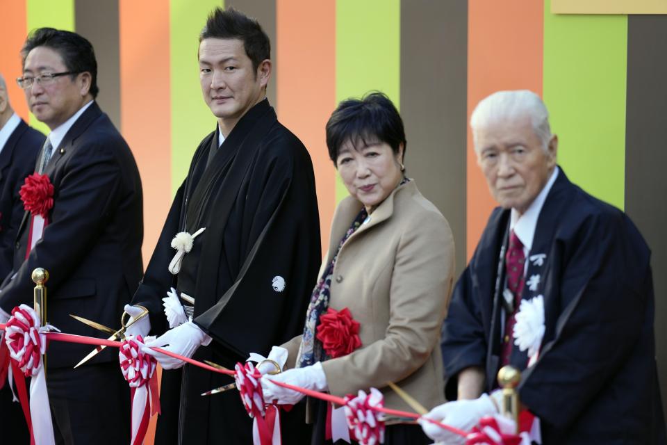 Guests attend the ribbon cutting during the opening ceremony of "Toyosu Senkyaku Banrai," an Edo Period-themed hot spring complex at Toyosu Fish Market Thursday, Feb. 1, Tokyo. Japan's biggest fish market on Thursday opened a long-awaited outer section with Japanese-style seafood restaurants and a spa for relaxation, as the wholesale venue that has struggled since relocating from the beloved Tsukiji market seeks to lure more visitors. (AP Photo/Eugene Hoshiko)