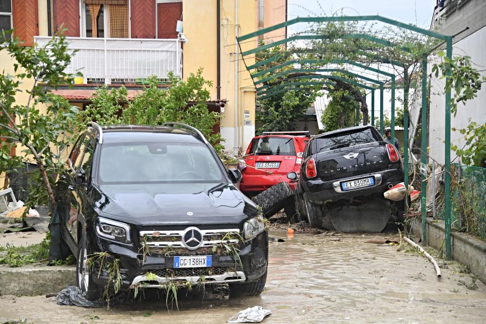 This picture taken in Cesena on May 17, 2023, shows damaged cars in a flooded street in San Rocco district after the flooding of the Savio river.