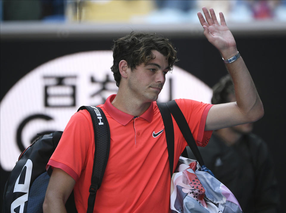 Taylor Fritz of the U.S. waves as he leaves the court after losing his third round singles match to Austria's Dominic Thiem at the Australian Open tennis championship in Melbourne, Australia, Saturday, Jan. 25, 2020. (AP Photo/Andy Brownbill)