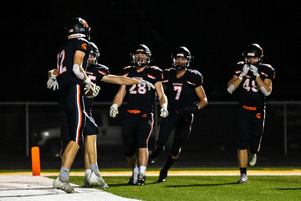 Solon's Rhyse Wear (12) celebrates with teammates after scoring a touchdown Friday against Washington at Spartan Stadium.