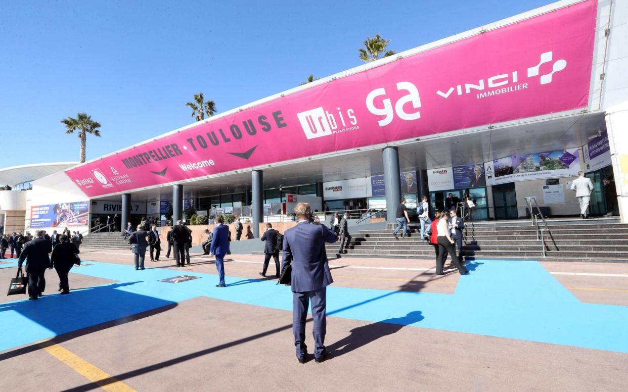 People walk outside the Palais des Festivals during the MIPIM international real estate show for professionals - AFP