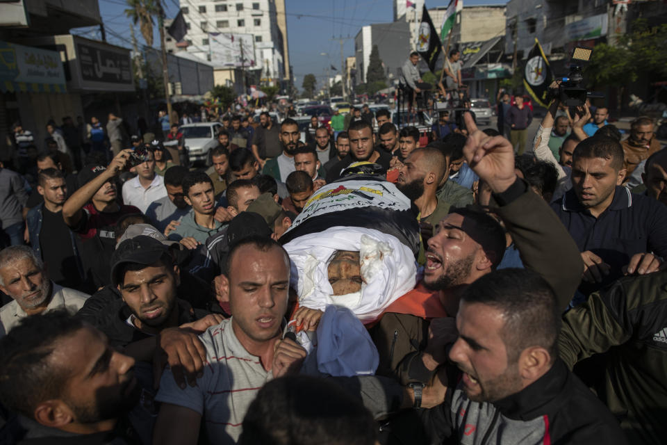 Palestinians chant angry slogans as they carry the body of Islamic Jihad commander, Bahaa Abu el-Atta, who was killed with his wife by an Israeli missile strike on their home, during his funeral in Gaza City, Tuesday, Nov. 12, 2019. (AP Photo/Khalil Hamra)