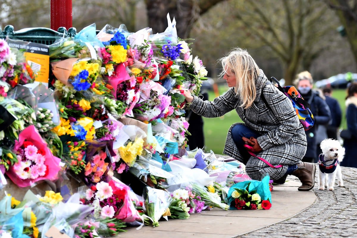 Tributes paid to Sarah Everard at Clapham Common vigil: A well-wisher places flowers at a bandstand (AFP via Getty Images)