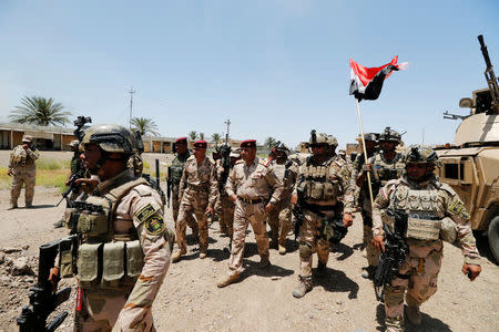 Baghdad Operations Command's head Lieutenant-General Abdul Ameer al-Shammari (C) walks in the town of Garma, Iraq, May 26, 2016. REUTERS/Thaier Al-Sudani