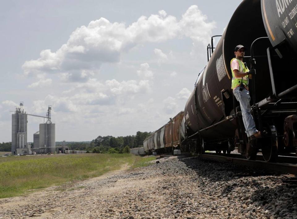 Lancaster & Chester Railroad Railway conductor, Nick Faile, rides the side of a train car, which moves goods to and from the Circle S Feedmill. The L&C Railway provides Chester County, South Carolina, industries with a cost efficient way of transporting goods.