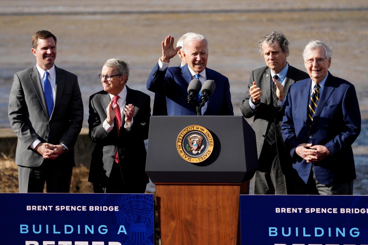 President Joe Biden is joined on stage by (left to right) Kentucky Gov. Andy Beshear, Ohio Gov. Mike DeWine, then-Sen. Rob Portman, Sen. Sherrod Brown, and Sen. Mitch McConnell, at a January speech in Covington, Kentucky to announce funding for Brent Spence Bridge.