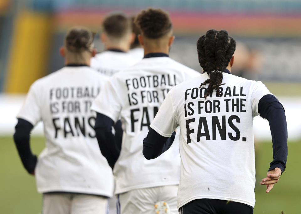 <p>Leeds United players wear t-shirts with the logo 'Football Is For The Fans' as they warm-up ahead of ahead of the English Premier League soccer match between Leeds United and Liverpool at the Elland Road stadium in Leeds, England, Monday, April 19, 2021. (Clive Brunskill/Pool via AP)</p>
