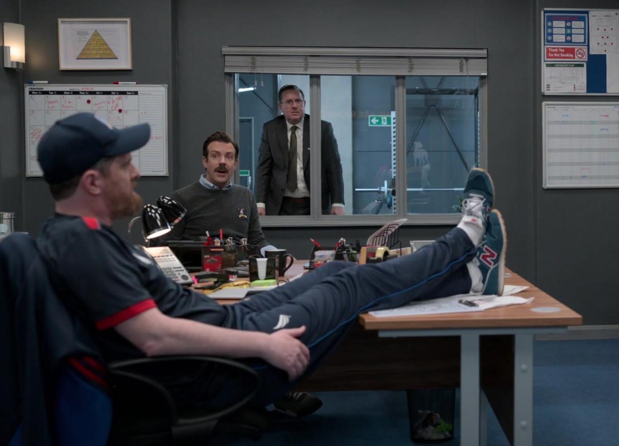 <span class="caption">New Balance shoes are front and center in a scene from 'Ted Lasso.'</span> <span class="attribution"><a class="link " href="https://productplacementblog.com/tv-series/new-balance-blue-shoes-worn-by-brendan-hunt-as-coach-beard-in-ted-lasso-s02e06-the-signal-2021/" rel="nofollow noopener" target="_blank" data-ylk="slk:Product Placement Blog/Universal Television;elm:context_link;itc:0;sec:content-canvas">Product Placement Blog/Universal Television</a></span>