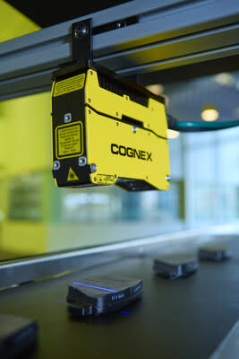 Cognex In-Sight L38 instalado sobre una línea de ensamblaje, inspeccionando productos en 3D.