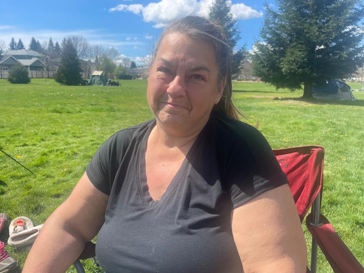 Laura Gutowski, 55, sits in a folding chair outside her tent in Morrison Centennial Park in Grants Pass, Ore., on April 2. The Supreme Court could determine whether unhoused residents like Gutowski can face tickets and be arrested for sleeping outside.