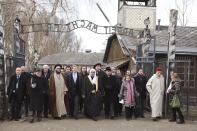 FILE - In this Thursday, Jan. 23, 2020, file photo, a delegation of Muslim religious leaders at the gate leading to the former Nazi German death camp of Auschwitz, together with a Jewish group in what organizers called "the most senior Islamic leadership delegation" to visit the former Nazi death camp, in Oswiecim, Poland. Saudi Arabia insists officially that there can be no formal ties with Israel before Palestinian statehood is achieved, but state-backed media and clerics have softened their tone toward Jews and there has been no official condemnation or criticism of the deals signed by the UAE or Bahrain with Israel. (American Jewish Committee via AP, File)