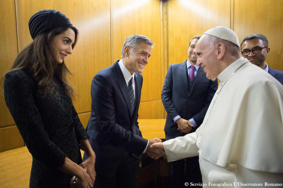 Pope Francis meets US actor George Clooney (C) and his wife Amal (L) during a meeting of the Scholas Occurrentes at the Vatican, May 29, 2016. Osservatore Romano/ Handout via REUTERS.