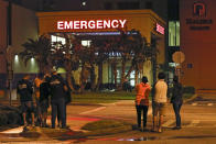 Race fans wait outside the emergency room of Halifax Health Medical Center where Ryan Newman was taken after he was involved in a crash during the final lap of the NASCAR Daytona 500 auto race at Daytona International Speedway, Monday, Feb. 17, 2020, in Daytona Beach, Fla. (AP Photo/Terry Renna)