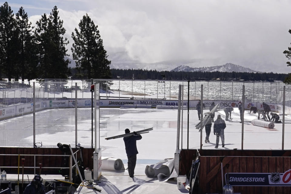 Workers put the finishing touches on the temporary ice rink, Friday, Feb. 19, 2021, built at the Edgewood Tahoe Resort, that will host two NHL games, this weekend at Stateline, Nev. The Colorado Avalanche will play the Vegas Golden Knights Saturday and the Philadelphia Flyers will face off against the Boston Bruins Sunday. (AP Photo/Rich Pedroncelli)