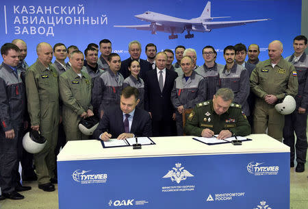 Russian President Vladimir Putin, United Aircraft Corporation (UAC) President Yury Slyusar and Deputy Defence Minister Yuri Borisov attend a signing ceremony at the Gorbunov Aviation factory in Kazan, Russia January 25, 2018. Sputnik/Alexei Nikolsky/Kremlin via REUTERS