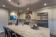 <p>The kitchen features a massive centre island and modern appliances. (Zillow) </p>