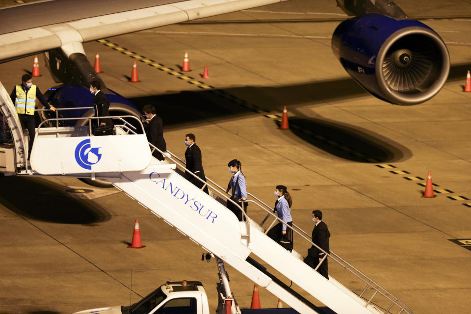 The crew of the plane who will transport the passengers from the Australian cruise ship Greg Mortimer, to be flown to Australia, walk up the plane's stairs at the international airport in Montevideo, Uruguay, Saturday, April 11, 2020. Uruguay evacuated Australians and New Zealanders Friday from the cruise ship that has been anchored off the South American country coast since March 27 with more than half its passengers and crew infected with the new coronavirus. (AP Photo/Matilde Campodonico)