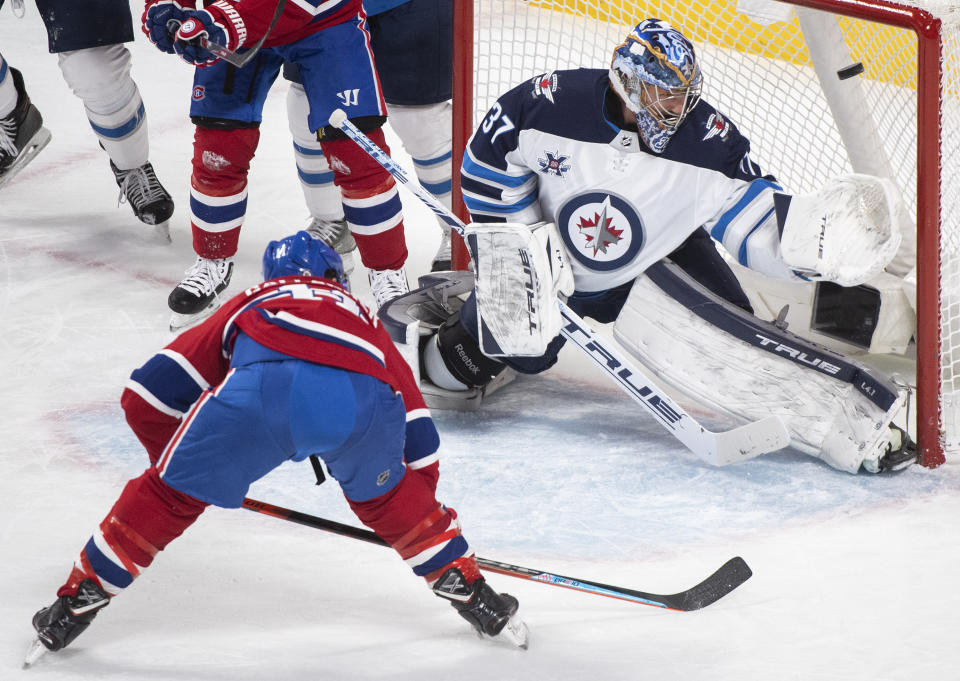 Montreal Canadiens' Brendan Gallagher (11) scores against Winnipeg Jets goaltender Connor Hellebuyck during the second period of an NHL hockey game Saturday, March 6, 2021, in Montreal. (Graham Hughes/The Canadian Press vIa AP)