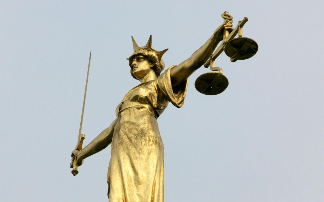 A statue representing the scales of justice - TOBY MELVILLE 