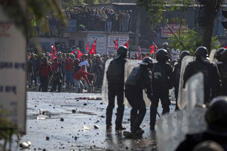 Protesters clash with police in a rally demanding a restoration of Nepal's monarchy in Kathmandu, Nepal, Thursday, Nov. 23, 2023. Riot police used batons and tear gas to halt tens of thousands of supporters of Nepal's former king demanding the restoration of the monarchy and the nation's former status as a Hindu state. Weeks of street protests in 2006 forced then King Gyanendra to abandon his authoritarian rule and introduce democracy. (AP Photo/Niranjan Shrestha)