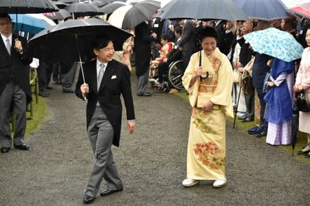 FILE PHOTO: Japan's Crown Prince Naruhito and Crown Princess Masako greet guests during an autumn garden party at Akasaka Palace Imperial garden in Tokyo