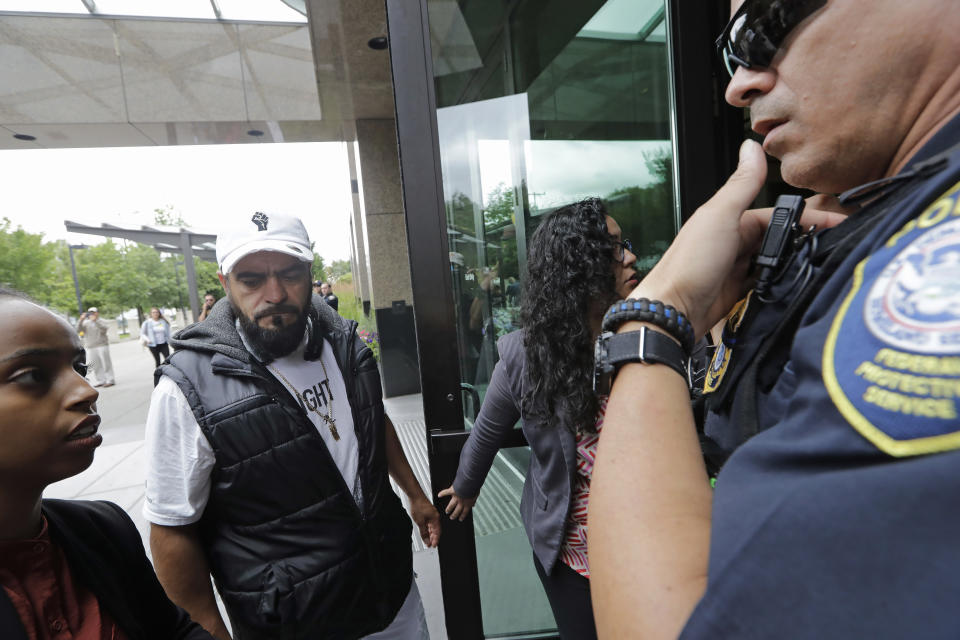 In this photo taken Wednesday, July 17, 2019, Jose Robles, second left, turns himself in to U.S. Immigration and Customs Enforcement officials in Tukwila, Wash. The prospect of nationwide immigration raids has provided evidence that legions of pastors, rabbis and their congregations stand ready to help vulnerable immigrants with offers of sanctuary and other services. (AP Photo/Elaine Thompson)