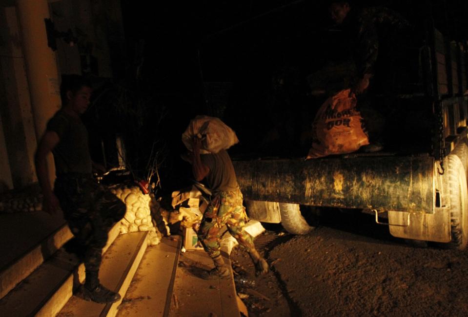 Soldiers stock up a distribution depot with supplies after the Super typhoon Haiyan battered Tacloban city in central Philippines