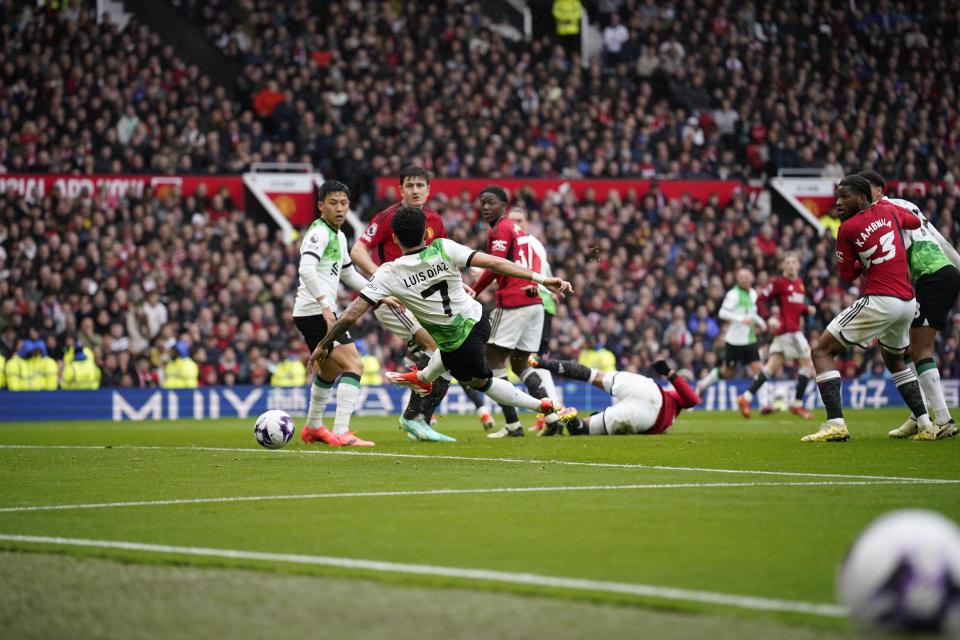 Liverpool's Luis Diaz, centre, scores the opening goal during the English Premier League soccer match between Manchester United and Liverpool at the Old Trafford stadium in Manchester, England, Sunday, April 7, 2024. (AP Photo/Dave Thompson)