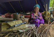 An internally displaced woman sits inside her makeshift tent at Pu Phar Village, Demawso Township, Kayah State on Thursday June 17, 2021. A report on the situation in conflict-affected areas of Myanmar issued this week by the U.N.'s Office for the Coordination of Humanitarian Affairs says around 108,800 people from Kayah State were internally displaced following an escalation of hostilities between the government military and the local Karenni People's Defense Force militia since the coup Feb. 1, 2021. (AP Photo)