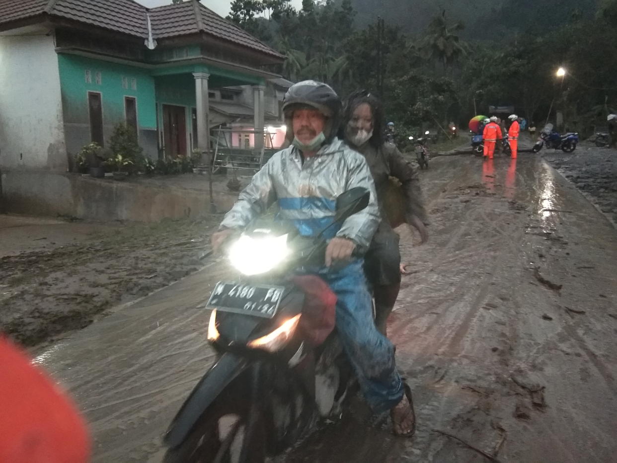 People ride a motorbike on a road that is covered with volcanic ash following an eruption of the Semeru mount volcano at Sumberwuluh village in Lumajang regency, East Java province, Indonesia, December 4, 2021, in this photo taken by Antara Foto. Antara Foto/Hermawan/via REUTERS       ATTENTION EDITORS - THIS IMAGE HAS BEEN SUPPLIED BY A THIRD PARTY. MANDATORY CREDIT. INDONESIA OUT. NO COMMERCIAL OR EDITORIAL SALES IN INDONESIA.