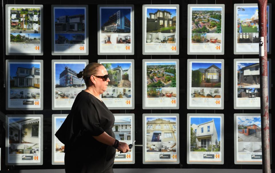 A woman walks past a real estate agent's window advertising houses for sale and auction in Melbourne on May 1, 2019. - Australian property prices fell faster in the past year than at any time since the global financial crisis, a closely watched report said May 1, fuelling speculation of a pre-election interest rate cut. (Photo by William WEST / AFP)        (Photo credit should read WILLIAM WEST/AFP via Getty Images)