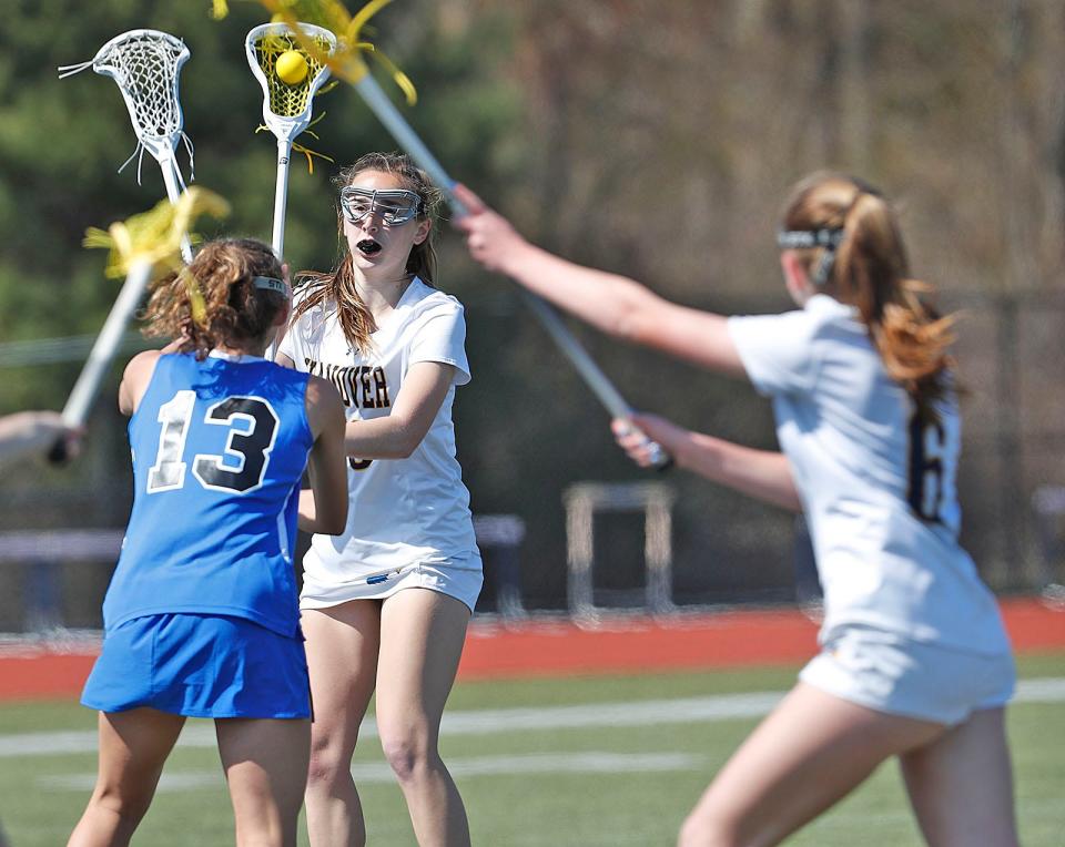 Hanover's Eva Kelliher tries to get a shot on Scituate's net over defender Casey McKeever. Hanover took on Scituate in girls lacrosse for the Patriot Cup on Friday, April 21, 2023.