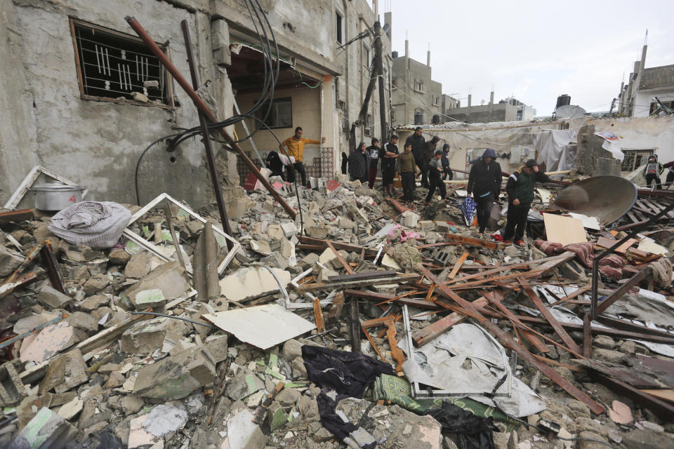 Palestinians look at destruction after Israeli strikes on Rafah, Gaza Strip, Wednesday, Nov. 15, 2023. As the military sets its sights on southern Gaza in its campaign to stamp out Hamas, key challenges loom. International patience for a protracted invasion has begun to wear thin. And with some 2 million displaced Gaza residents staying in crowded shelters in the south in dire conditions, a broad military offensive there could unleash a new humanitarian disaster during the cold, wet winter. (AP Photo/Hatem Ali)