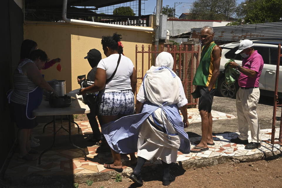 Una hermana de la orden Misioneras de la Caridad, quien es una de las 18 monjas expulsadas el año pasado de Nicaragua, supervisa una fila de alimentos en Las Canas, Costa Rica, el miércoles 1 de marzo de 2023. Las hermanas, recibidas por la Diócesis de Tilarán en julio, continúan con sus obras de caridad en Costa Rica. (Foto AP/Carlos González)