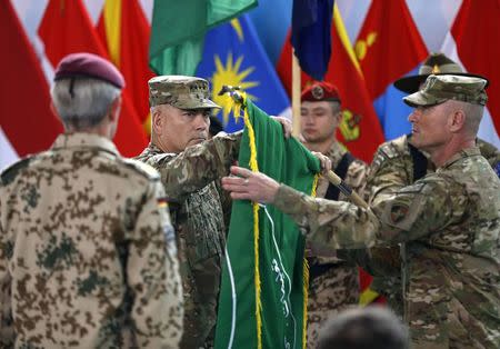 U.S. General John Campbell (C), commander of NATO-led International Security Assistance Force (ISAF), folds the flag of the ISAF during the change of mission ceremony in Kabul, December 28, 2014. REUTERS/Omar Sobhani