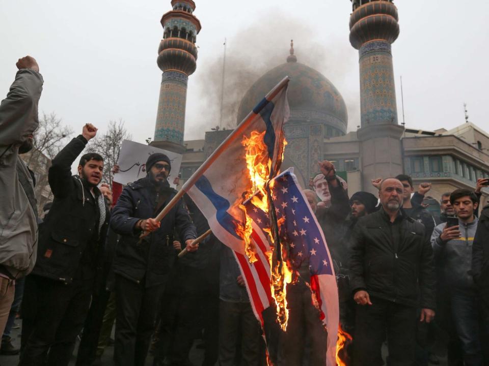 Iranians burn US and Israeli flags during an anti-US protest over the killings during a US air strike of Iranian military commander Qasem Soleimani and Iraqi paramilitary chief Abu Mahdi al-Muhandis, in the capital Tehran on January 4 (AFP via Getty Images)