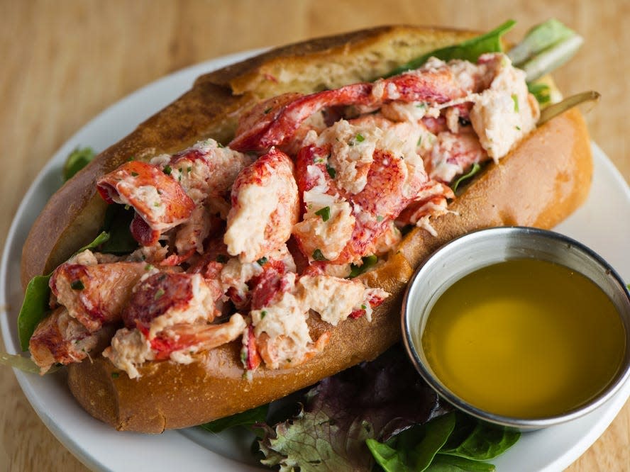 lobster roll on a plate with melted butter on the side