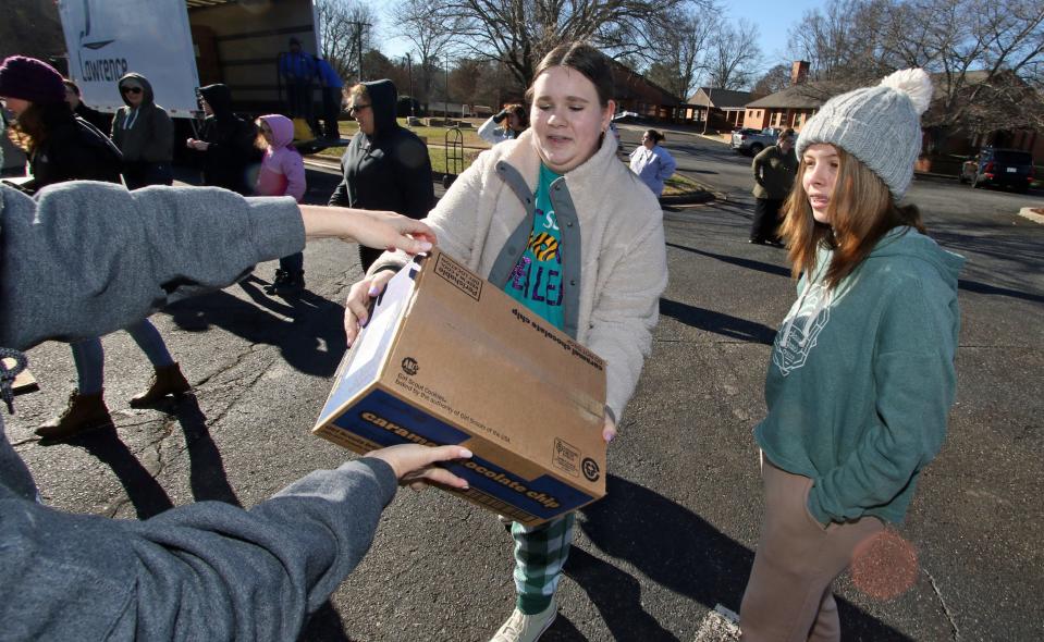 Erika Safrit and Cora Torres help stack cases of Girl Scout cookies Saturday morning, Jan. 13, 2024, in the parking lot of Aldersgate UMC in Shelby.