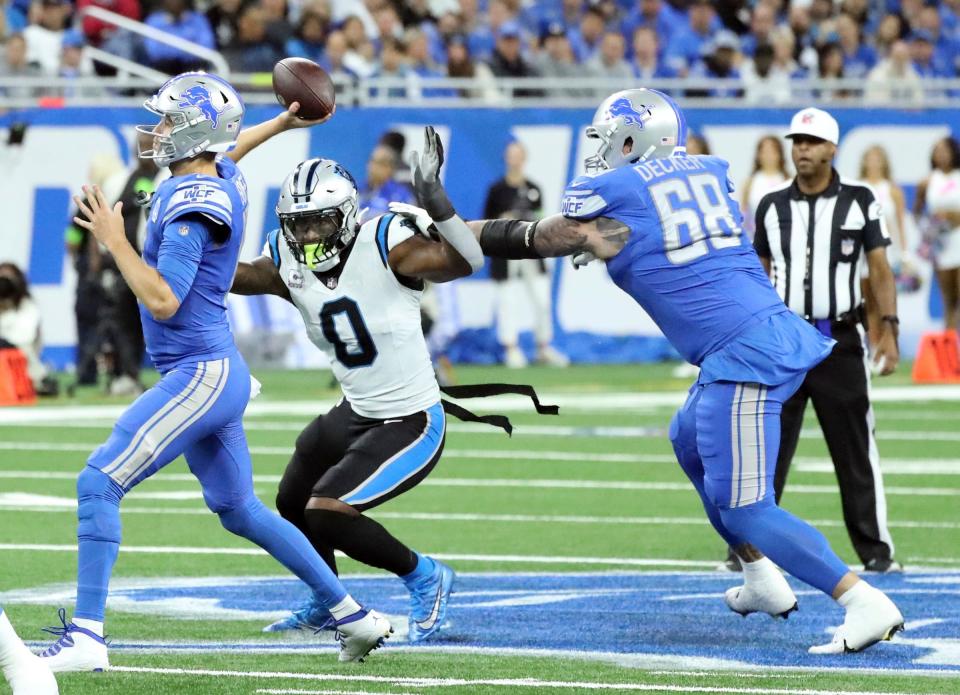 Detroit Lions quarterback Jared Goff passes as Carolina Panthers linebacker Brian Burns rushes against tackle Taylor Decker during first-half action at Ford Field on Sunday, Oct, 8, 2023.