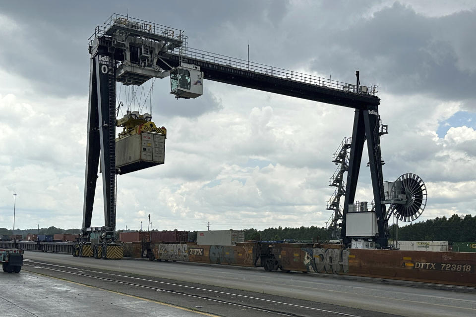 A Norfolk Southern crane unloads a shipping container from a train onto a truck trailer at the railroad's Austell rail yard in the Atlanta area on June 20, 2023. (AP Photo/Josh Funk)