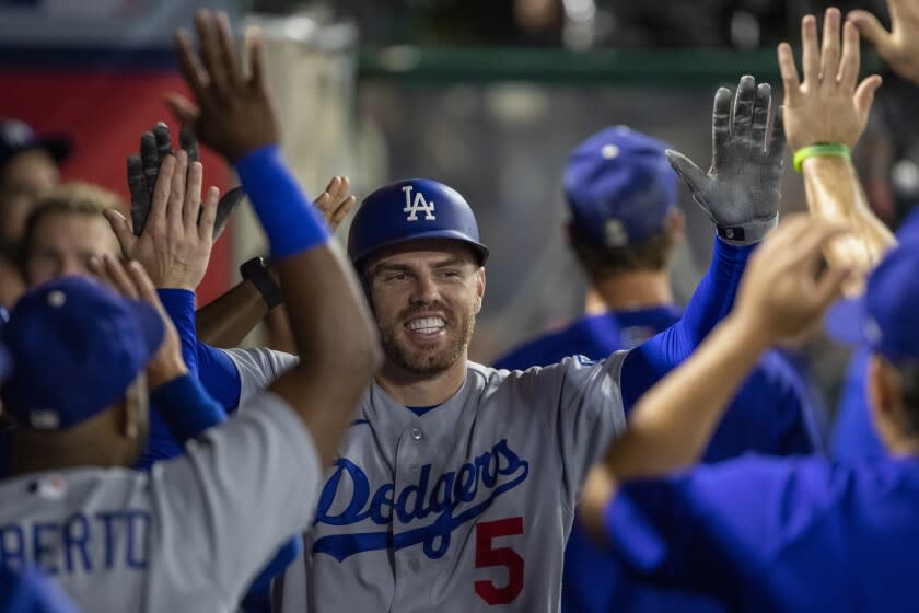 Los Angeles Dodgers' Freddie Freeman celebrates in the dugout after hitting a solo home run.