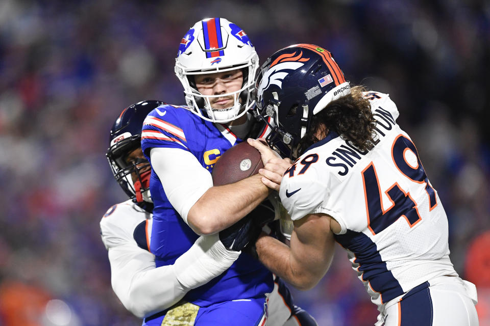 Denver Broncos' Baron Browning, left, and Alex Singleton (49) tackle Buffalo Bills quarterback Josh Allen, center, during the first half an NFL football game, Monday, Nov. 13, 2023, in Orchard Park, N.Y. (AP Photo/Adrian Kraus)