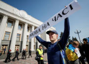 An activist attends a rally to demand lawmakers vote for a law that grants special status to the Ukrainian language and introduces mandatory language requirements for public sector workers, in front of the parliament building in Kiev, Ukraine April 25, 2019. The banner reads "High time for the language". REUTERS/Gleb Garanich