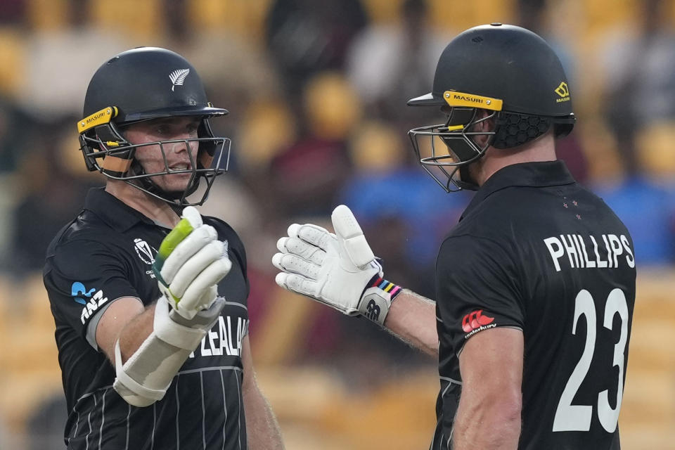 New Zealand's Tom Latham, left, congratulates teammate Glenn Phillips for scoring fifty runs during the ICC Cricket World Cup match between Afghanistan and New Zealand in Chennai, India, Wednesday, Oct. 18, 2023. (AP Photo/Eranga Jayawardena)