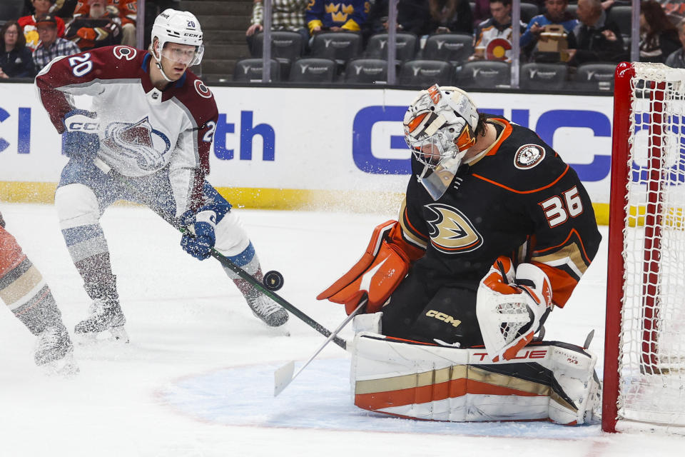 Anaheim Ducks goalie John Gibson (36) makes a save in front of Colorado Avalanche forward Lars Eller (20) during the first period of an NHL hockey game in Anaheim, Calif., Monday, March 27, 2023. (AP Photo/Ringo H.W. Chiu)