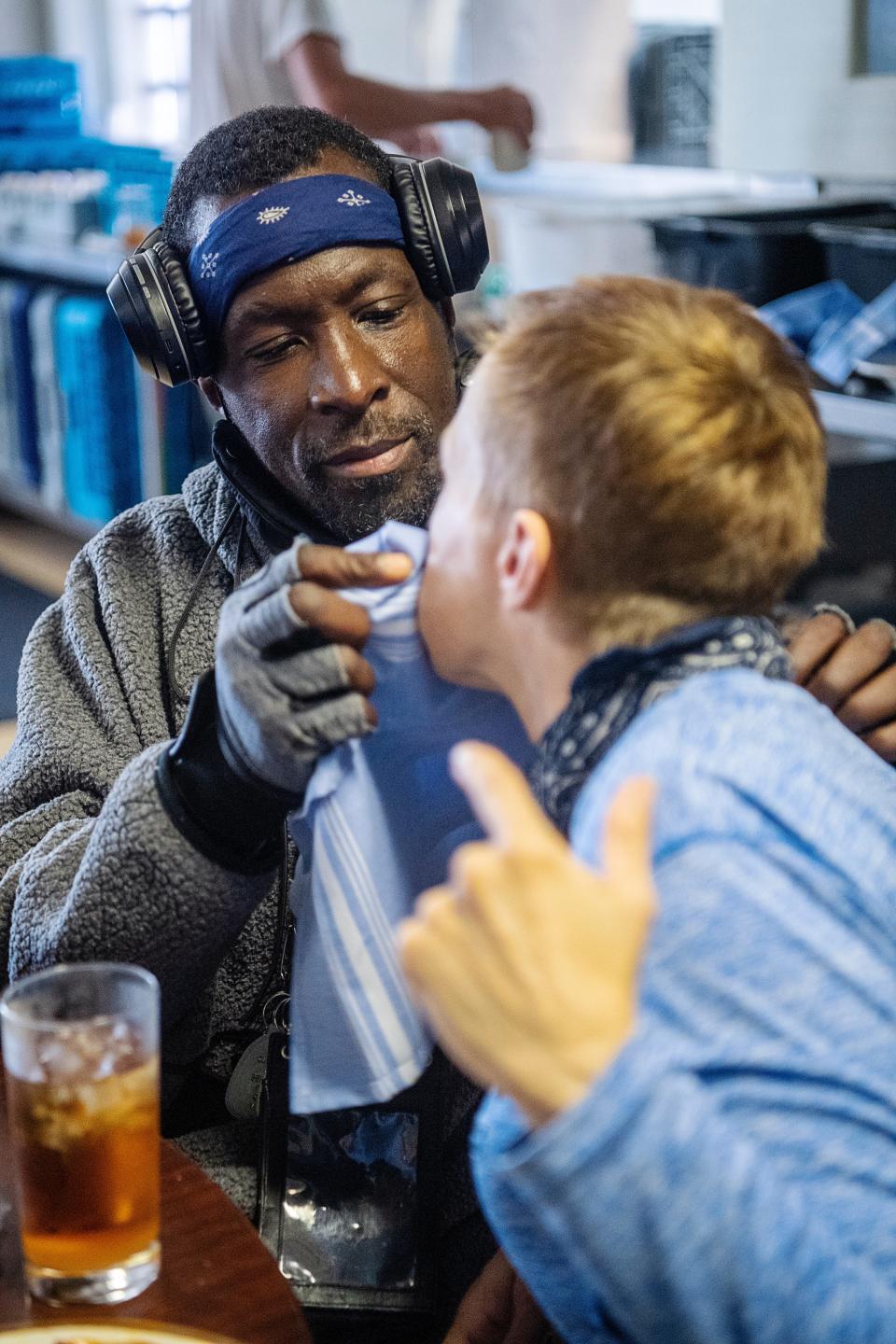 Jeffery Glenn wipes the face of his fiancée, Christie, while they eat at Haywood Street Congregation, November 8, 2023.